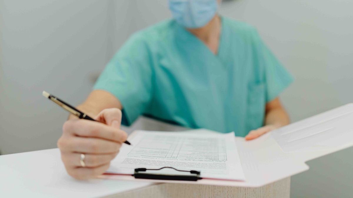 Operatore sanitario compila un modulo: controlli e prevenzione della corruzione nelle strutture sanitarie